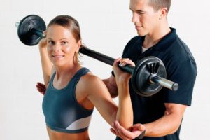 Trainer und Frau im Fitnessstudio